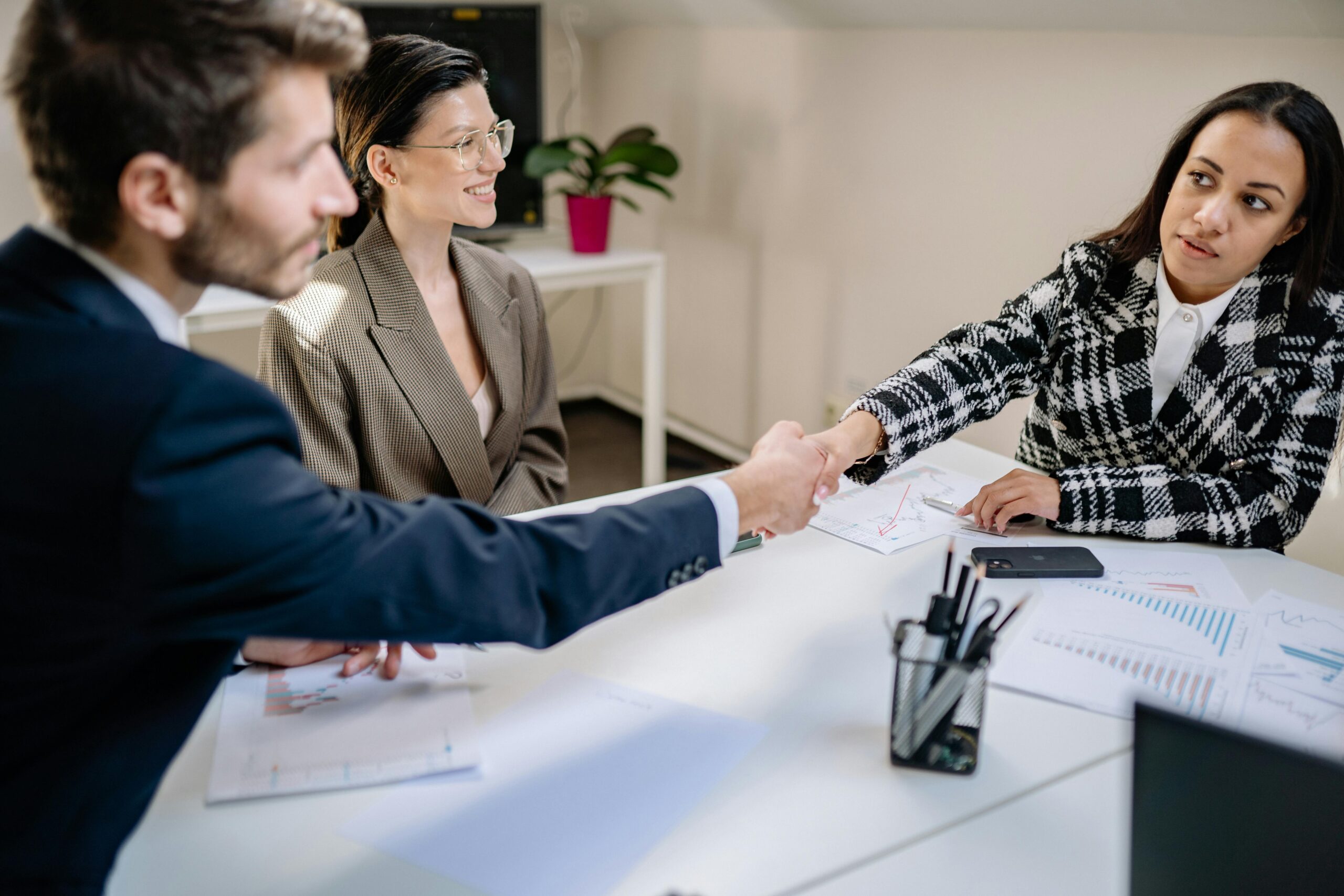 HR professional and employees meeting and shaking hands during a workplace discussion, representing efforts to bridge the employee–HR relationship gap