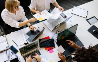 Team collaborating on year-end projects in a busy office, illustrating workplace pressure, leadership support, and December employee motivation.